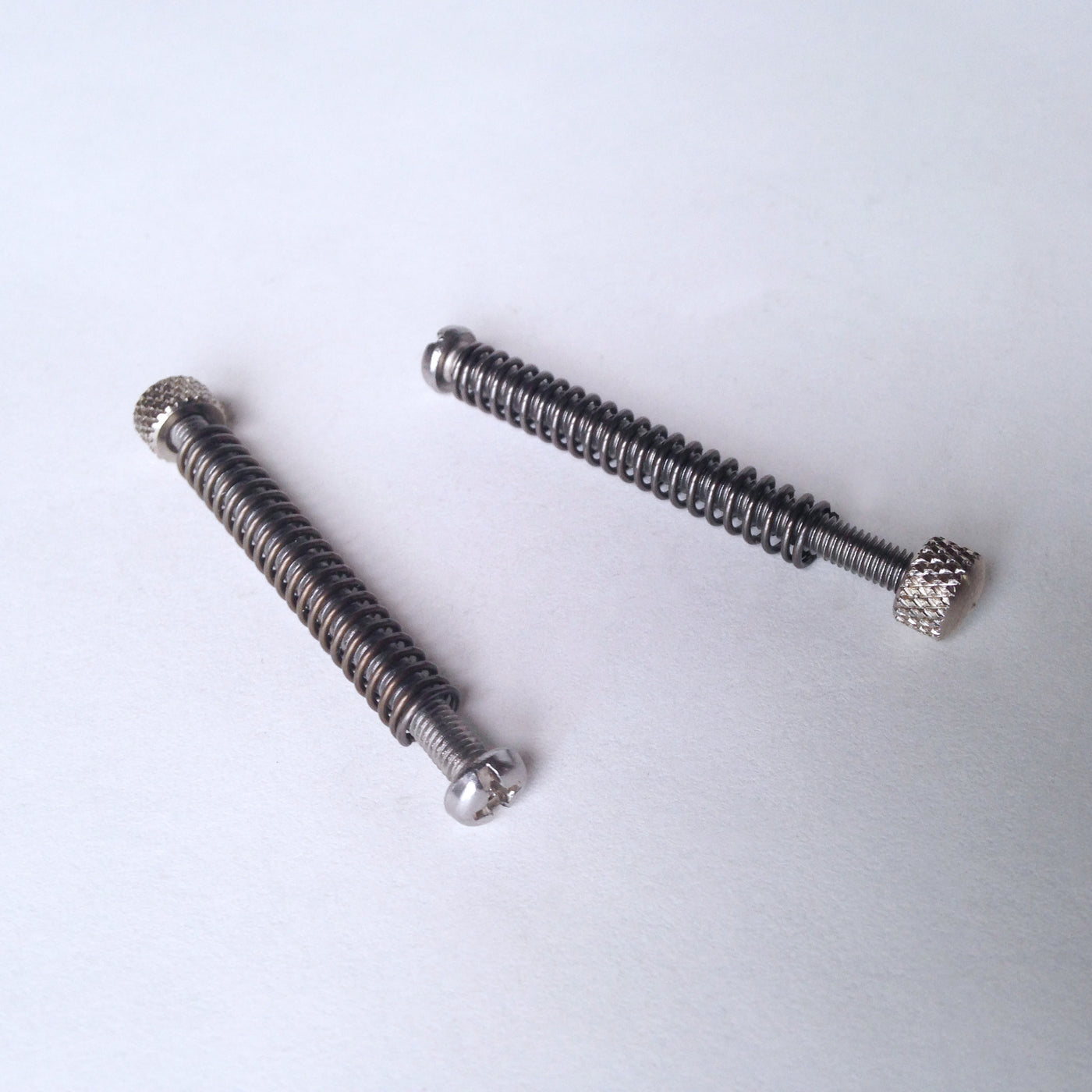 Dropout adjustment screws with springs and end-nuts
